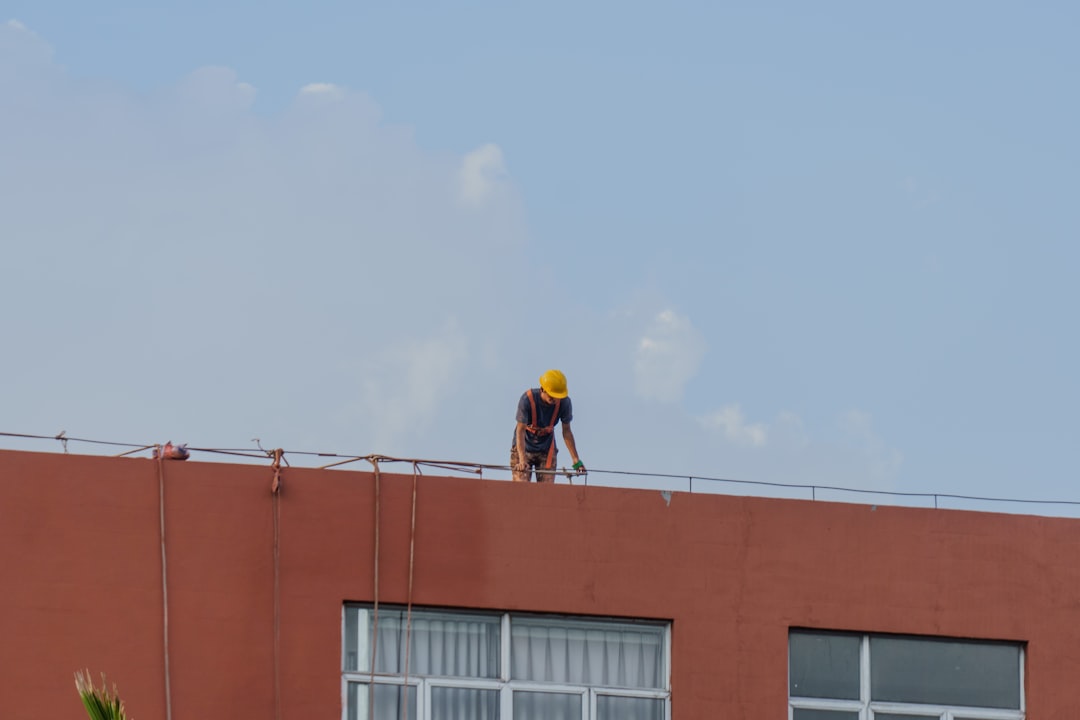 A commercial HVAC technician inspecting a large rooftop unit on a building - commercial hvac repair des moines A commercial HVAC technician inspecting a large rooftop unit on a building - commercial hvac repair des moines