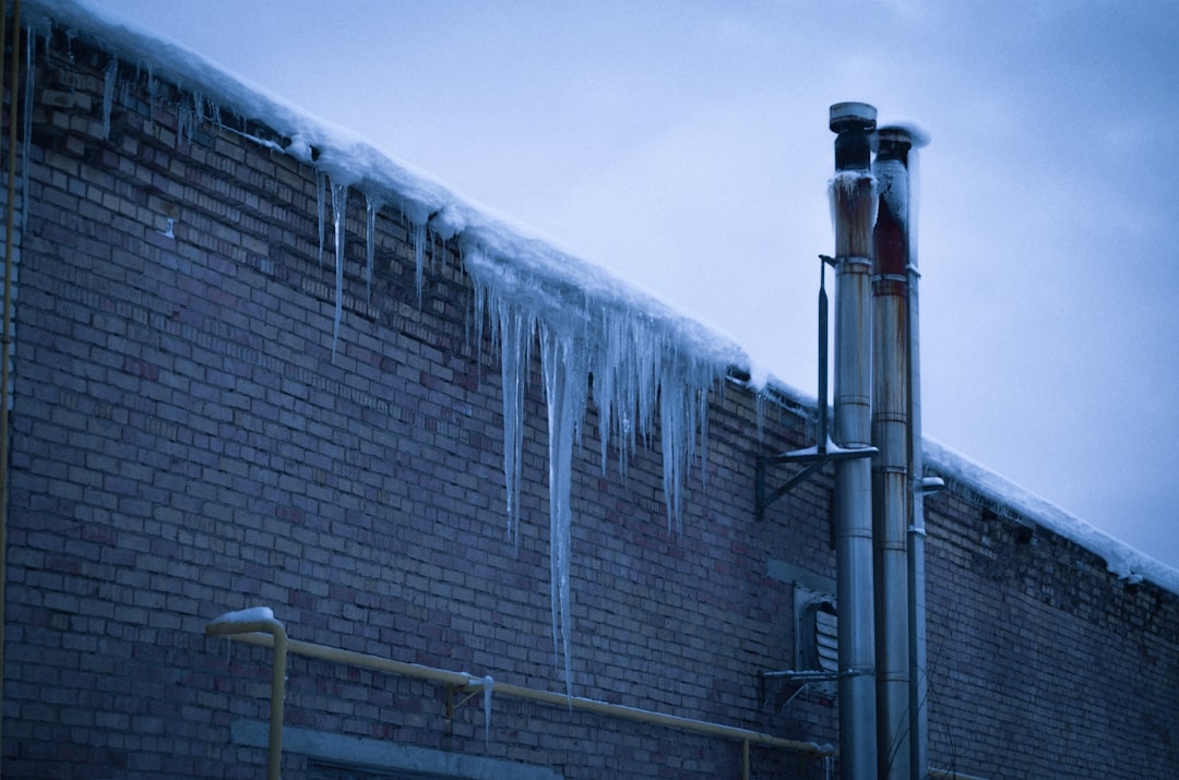 an ice-covered outdoor vent pipe on the side of a residential home