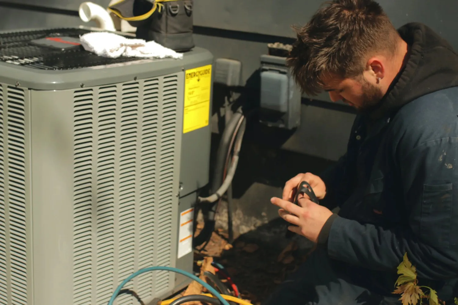 HVAC technician inspecting home AC unit air filter to check for dirt and moisture HVAC technician inspecting home AC unit air filter to check for dirt and moisture
