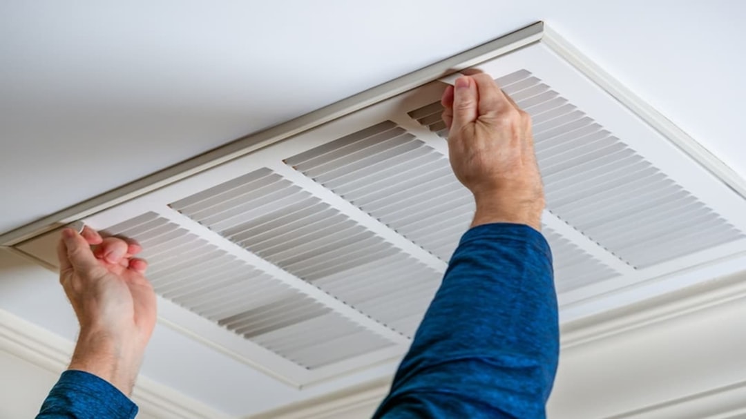 Homeowner checking a clean air filter in their indoor unit - heat pump maintenance tips