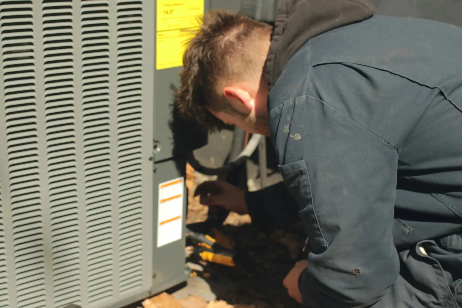 Technician performing a seasonal HVAC system check on a home unit Technician performing a seasonal HVAC system check on a home unit