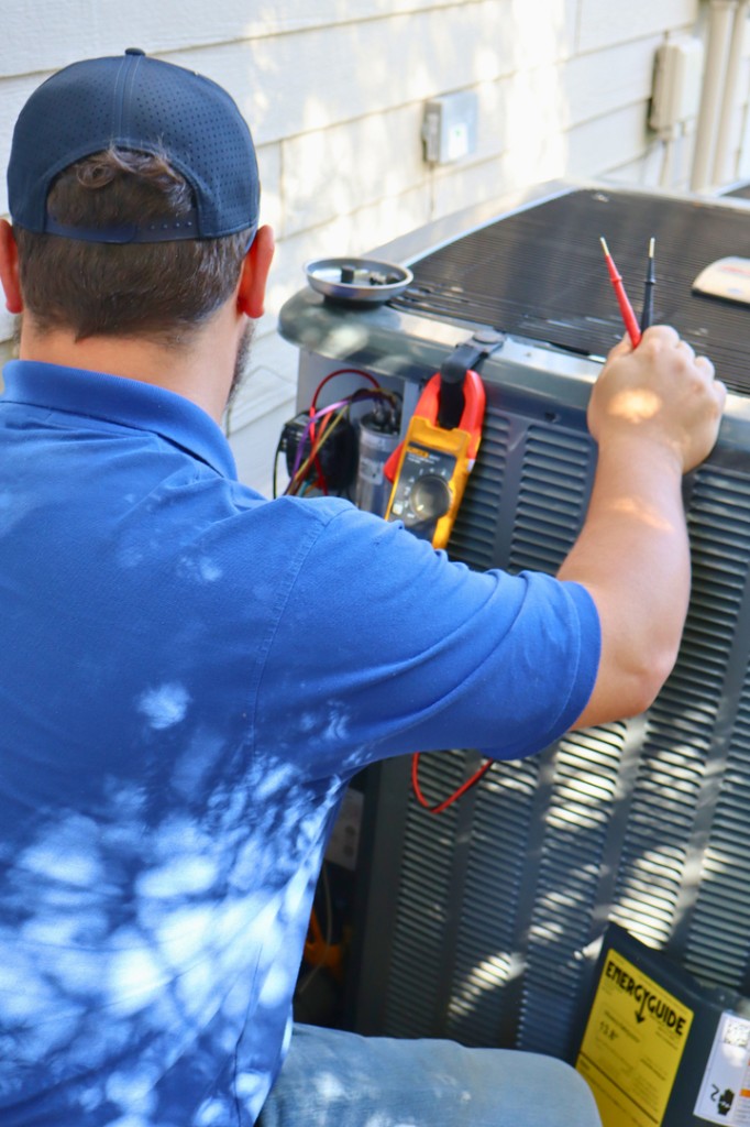 Midwest Comfort technician servicing a residential outdoor AC unit
