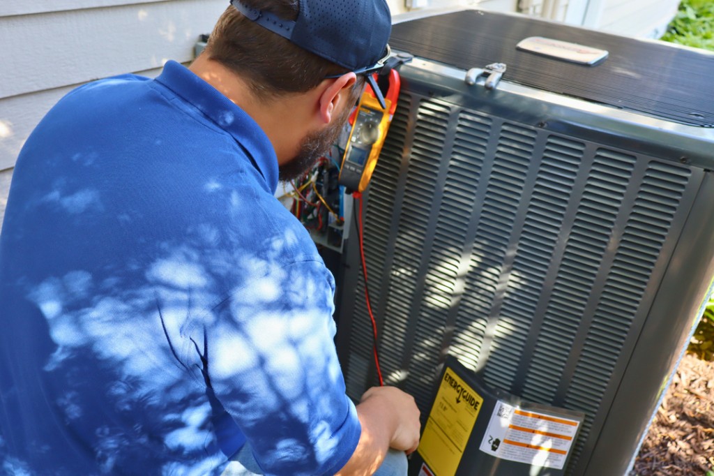 Midwest Comfort technician working on an outdoor AC condenser