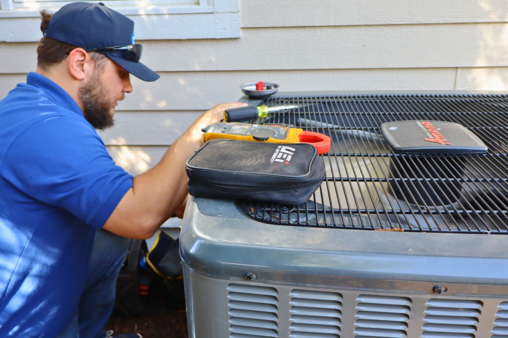 Midwest Comfort technician performing AC maintenance