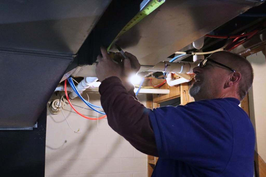 Midwest Comfort technician working on residential ductwork