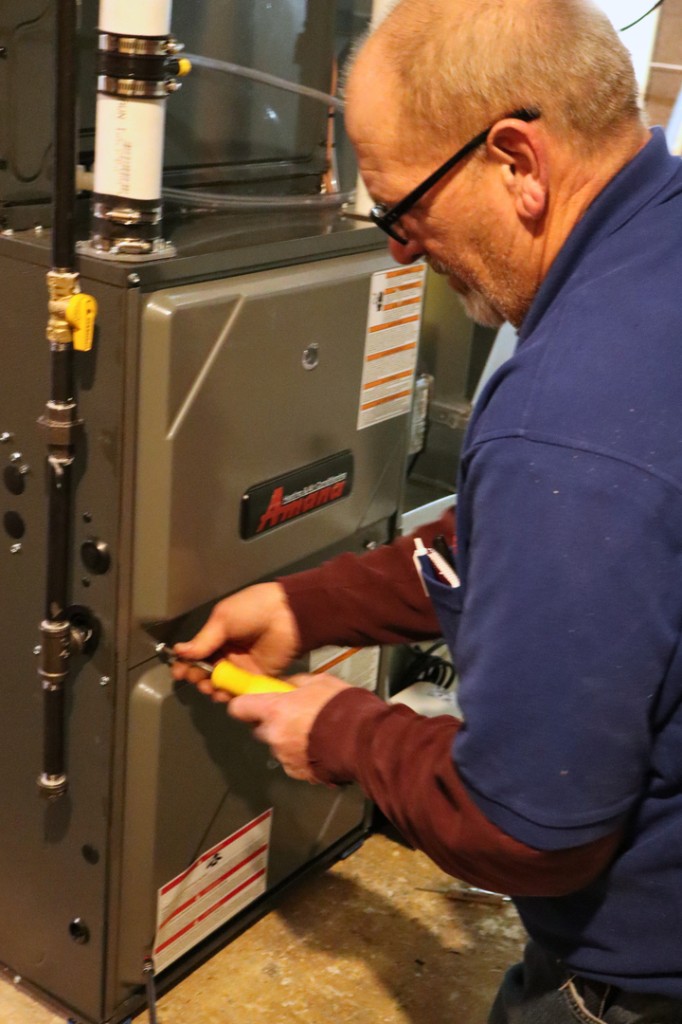 Midwest Comfort technician working on a residential gas furnace
