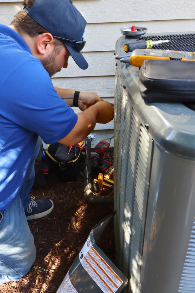 Midwest Comfort technician working on a residential outdoor AC unit