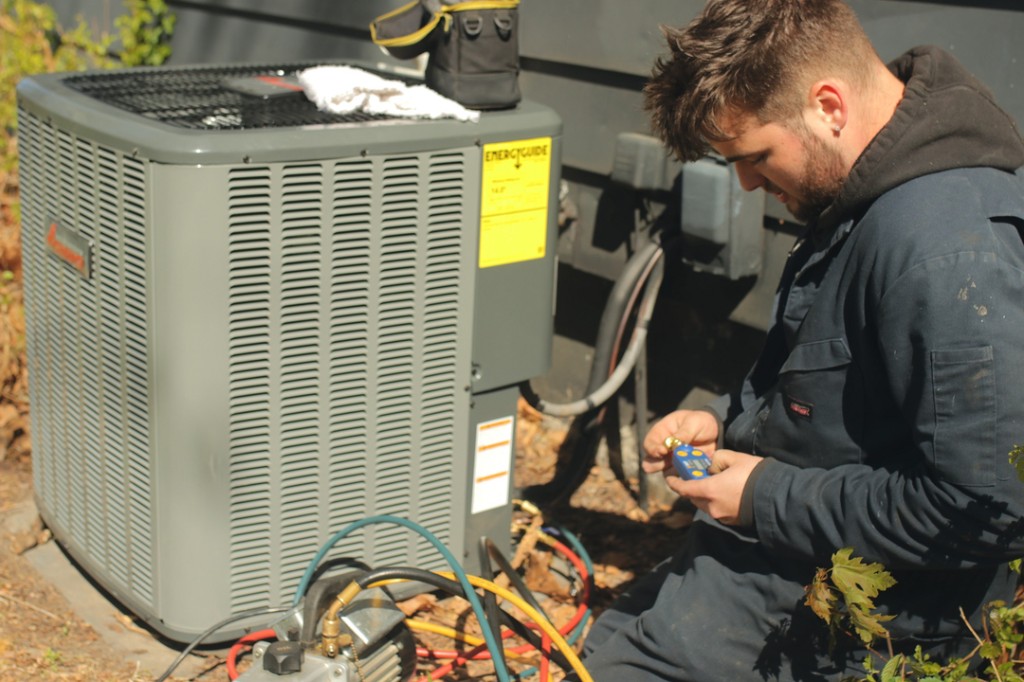 Midwest Comfort technician servicing a residential outdoor air-conditioning unit