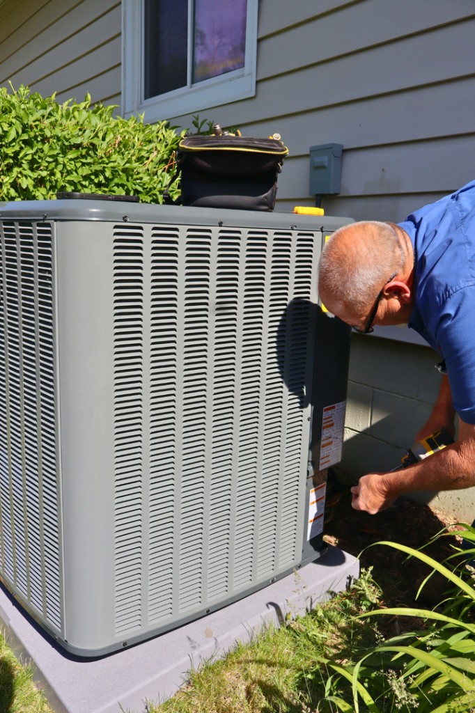 Midwest Comfort technician diagnosing a residential outdoor AC unit