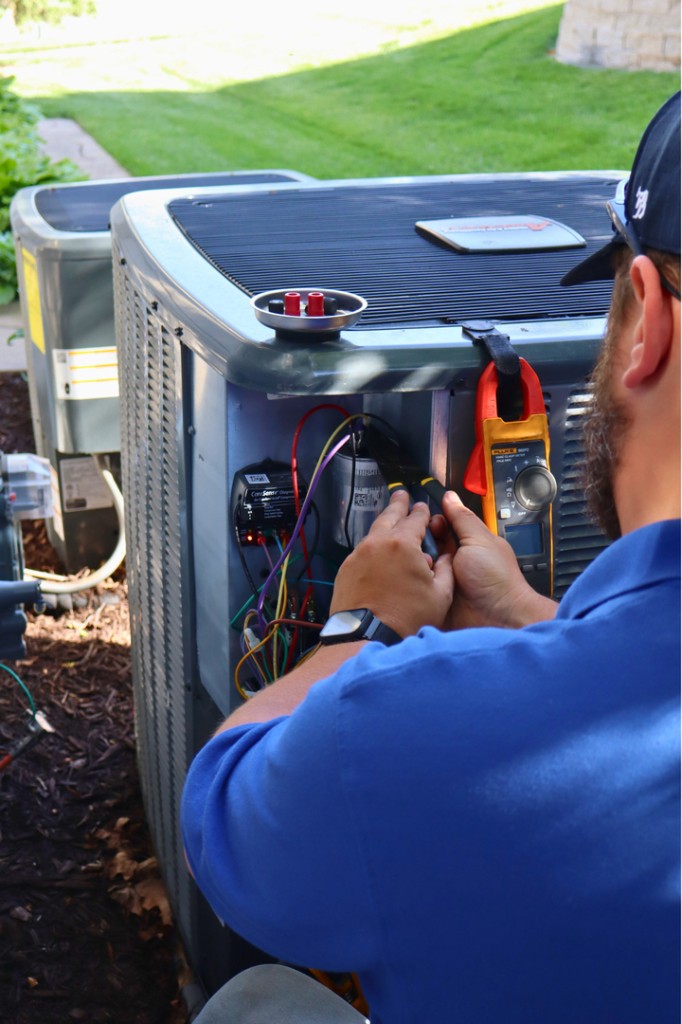 Midwest Comfort technician servicing a residential AC unit