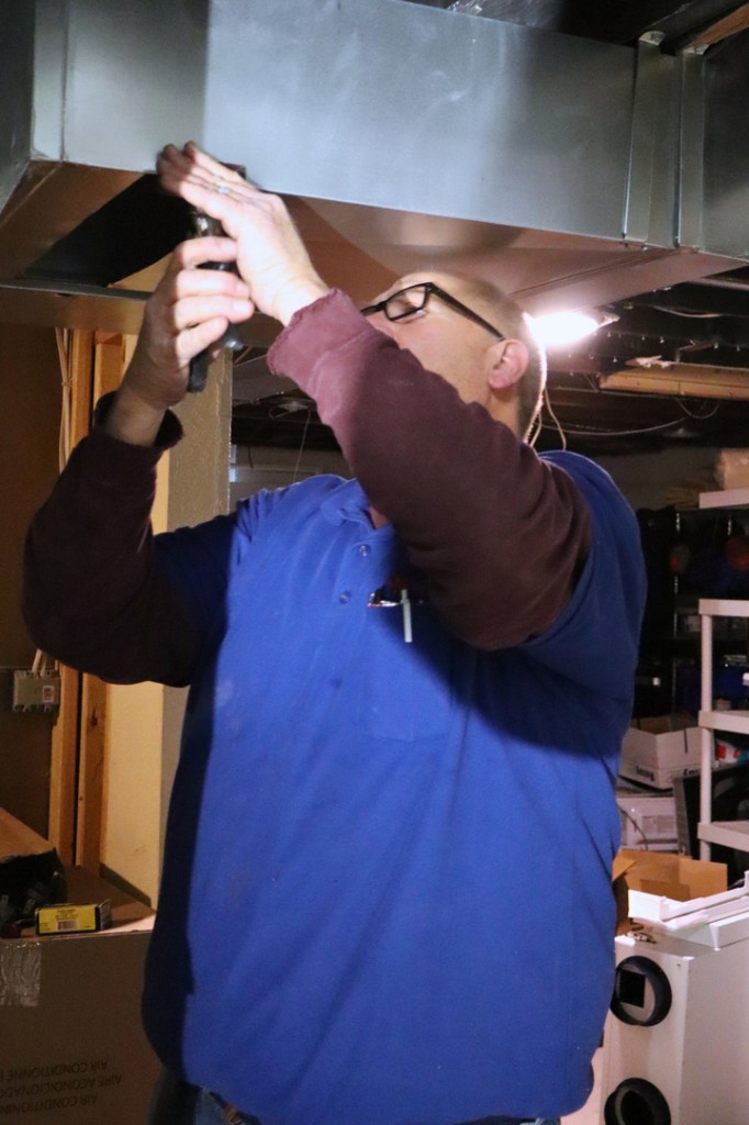 Midwest Comfort technician repairing residential ductwork