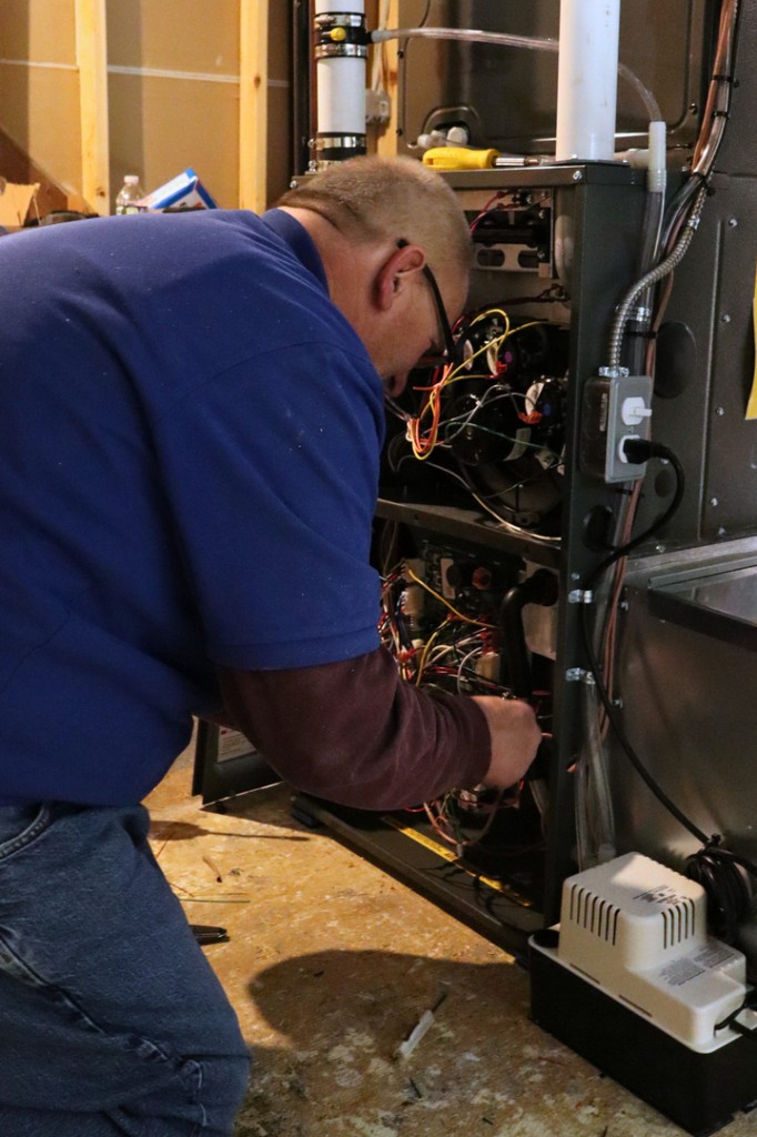 Midwest Comfort technician servicing a residential furnace