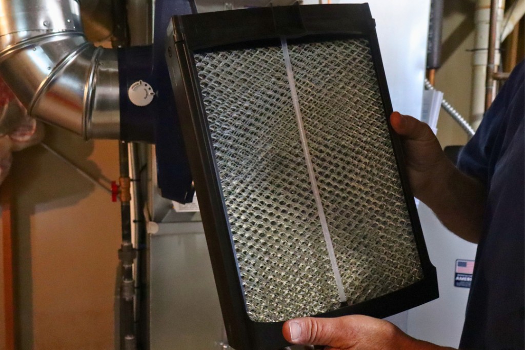 Midwest Comfort technician changing a high-efficiency furnace filter