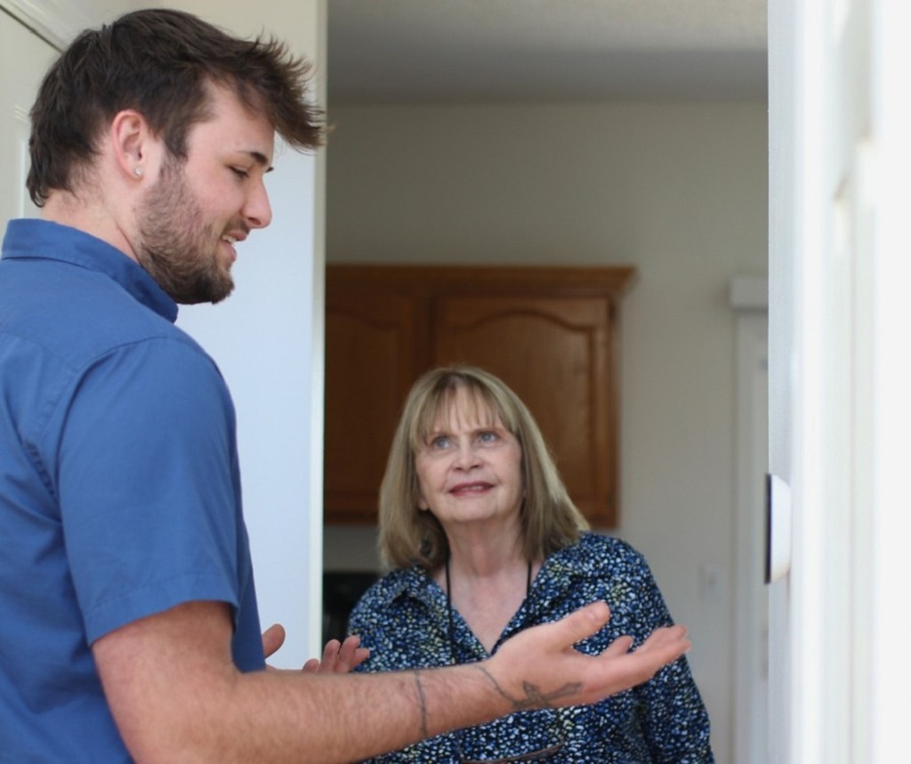 Midwest Comfort technician servicing a wall thermostat during a tune-up